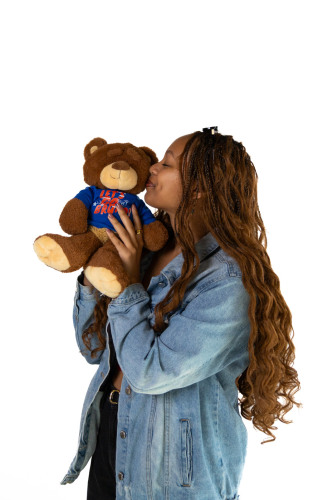 Abigail holding teddie bear bruno and giving him a kiss on the cheek