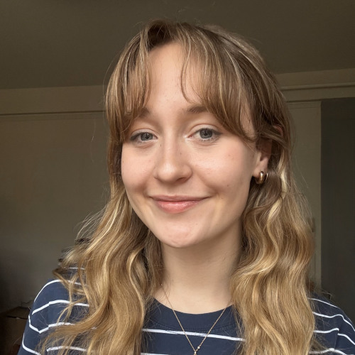 Elsa with a heart shaped locket in a blue shirt that has white stripes