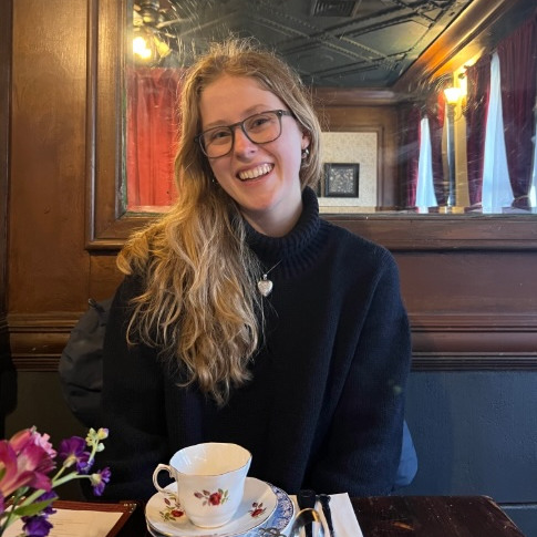 Student smiling at restaurant with teacup