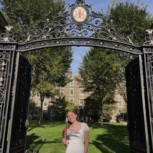 Student standing under Brown's Van Wickle Gates