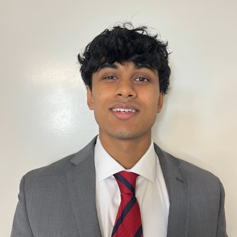 Student headshot wearing business formal clothing with red striped tie