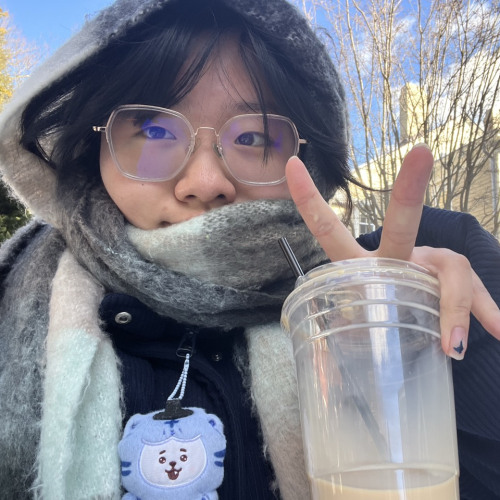 Image of Phoebe Yao holding a drink and making a peace sign